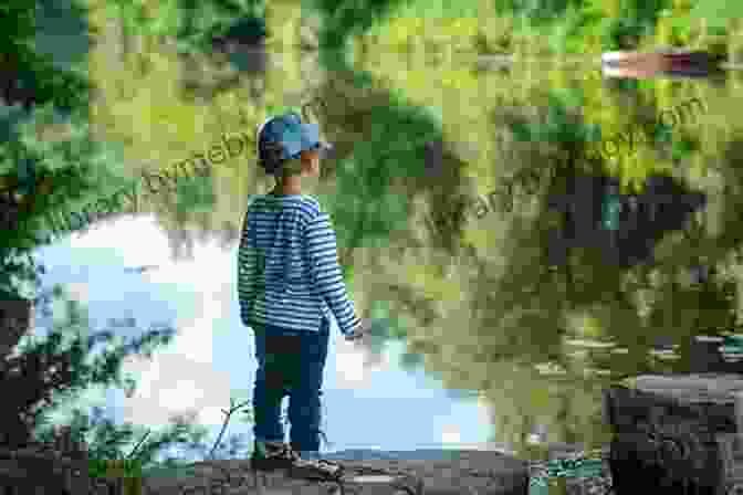 A Boy Stands On The Bank Of A River, Gazing Out At The Water. River Spirits: A Boy His River And Time